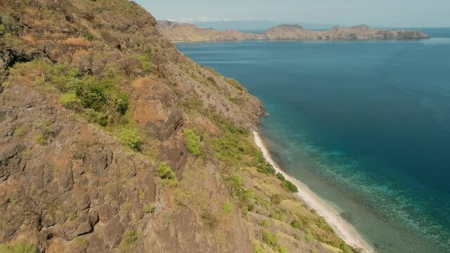 Wild islands of Indonesia. Flores. tropical paradise. Labuan Baggio. drone shooting. Wild beaches, blue logons, coral reefs, green hills. aerial view. boat trip safari. 