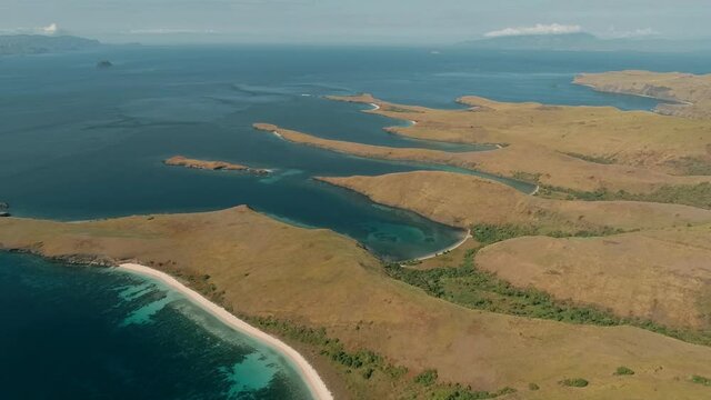 Wild islands of Indonesia. Flores. tropical paradise. Labuan Baggio. drone shooting. Wild beaches, blue logons, coral reefs, green hills. aerial view. boat trip safari. 
