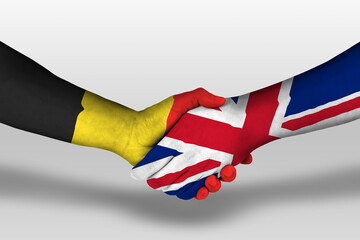 Handshake between united kingdom and belgium flags painted on hands, illustration with clipping...