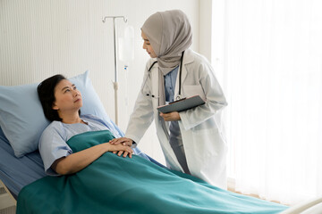 Asian female muslim doctors examination and treating patient in a hospital room