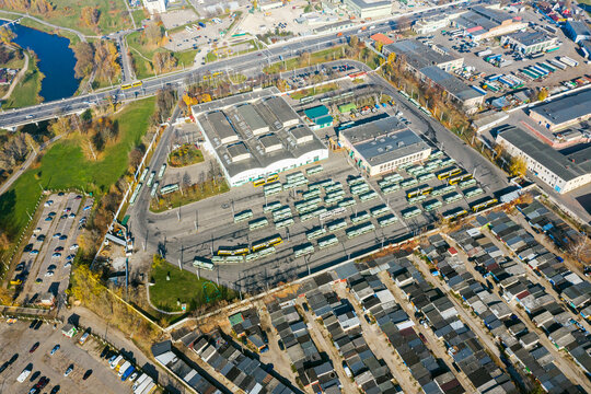 aerial image of cityscape. bus depot with parked buses and service buildings, warehouses and parking lot