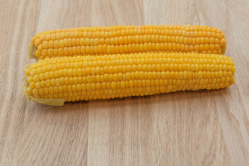 Boiled corn on a wooden background. Ready to eat. Corn benefits