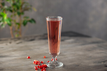 Pomegranate wine, seeds and pomegranate fruit on wooden background