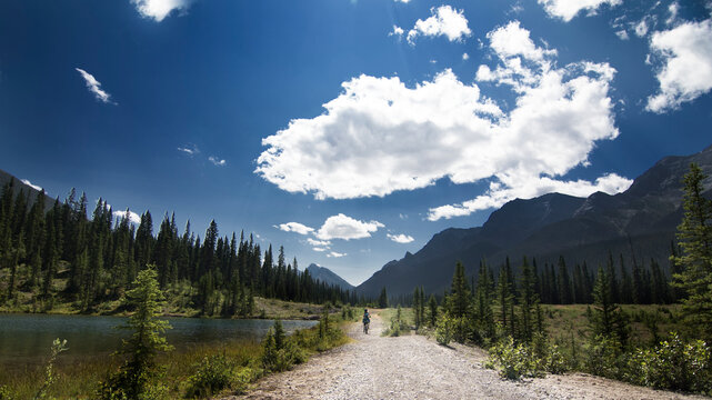 Mountain bikers ride the High Rockies Trail through Peter Lougheed Provincial Park under a dramatic summer sky. - Powered by Adobe