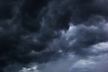 The dark sky with heavy clouds converging and a violent storm before the rain.Bad or moody weather sky and environment. carbon dioxide emissions, greenhouse effect, global warming, climate change.