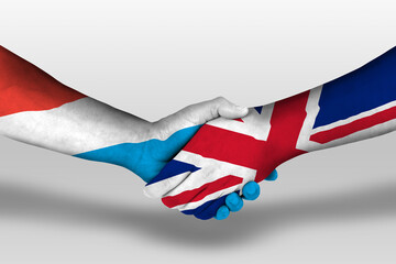 Handshake between united kingdom and luxembourg flags painted on hands, illustration with clipping path.