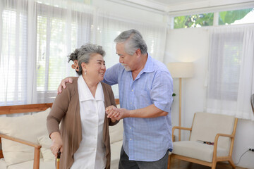 Happy middle-aged 60s husband carry carefully wife in living room peaceful elderly couple...