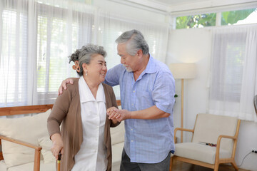 Happy middle-aged 60s husband carry carefully wife in living room peaceful elderly couple rest,taking care of each other in a happy retirement.