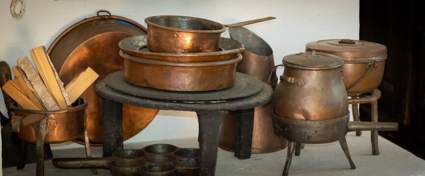 100 years old copper and cast iron kitchenware on a wood fired stove. Still life