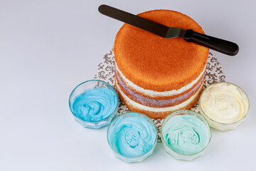 Sponge layered cake with spatula and icing.