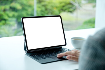 Mockup image of a woman touching on tablet touchpad with blank white desktop screen as computer pc in the office