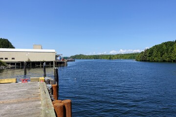A view of the waterfront and pier on the inside facing part of Ucluelet, with a view of the ocean inlet on a pretty sunny summer day