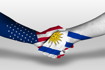 Handshake between uruguay and united states of america flags painted on hands, illustration with...