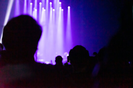concert playing in a crowded hall with the lights in the dark and the noise in the picture