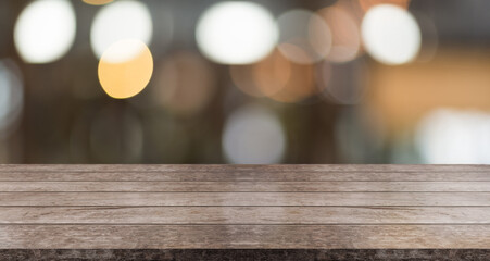Empty wooden table top with lights bokeh on blur restaurant background