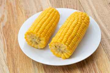 Freshly boiled corn on wooden background. Corn health benefits