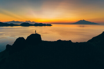 Padar island.Wild Indonesia. Flores. tropical paradise. Labuan Bajo. drone shooting. Wild beaches, aerial view. boat trip safari. one men watching the sunset or sunrise on the hill. Vulcano view