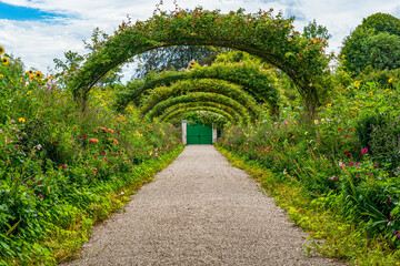Famous roses pathway to Monet's house at Giverny in summer - Giverny, France