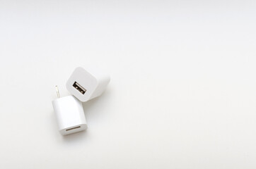 Cargador USB blanco en forma de cubo sobre fondo blanco.
