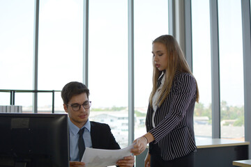 Business people sitting at desk and working with laptop computer.