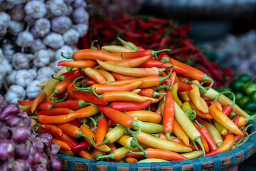 Orange, yellow and red sweet peppers for sale at street food market in the old town of Hanoi, Vietnam