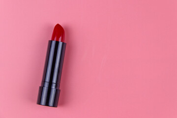 Red lipstick on a pastel pink background. Top view, copy space