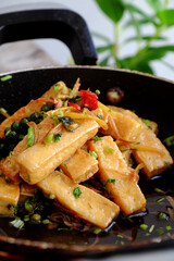Vietnamese vegetarian dish, fried tofu cook with sauce and ginger, simple vegan dish on pan
