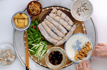 Vietnamese woman hand prepare breakfast, homemade vegan rice noodles roll from rice batter, delicious vegetarian stuffed dish
