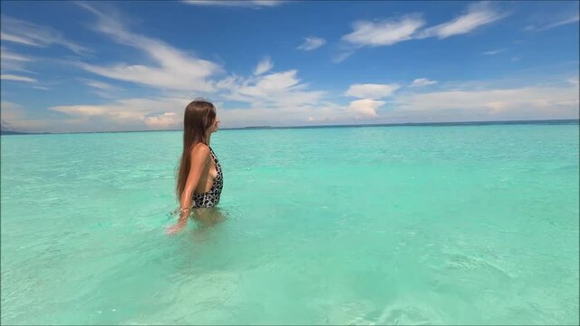 beautiful girl bathing in the sea near a tropical island