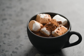 cup of hot chocolate with marshmallow on terrazzo background
