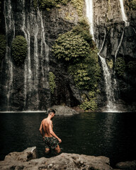 Fototapeta na wymiar Male model in a waterfall in Bali Indonesia