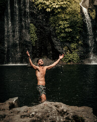 Fototapeta na wymiar Male model in a waterfall in Bali Indonesia