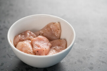 raw sliced chicken fillet meat in spices marinating in bowl