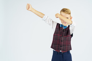 A portrait of a schoolboy who raised his hands up and makes a gesture with his hands. Isolated background.