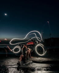 Male Model on a custom motorbike during sunset with light painting 