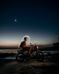 Male Model on a custom motorbike during sunset with light painting 