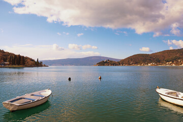 Naklejka na ściany i meble Sunny winter Mediterranean landscape. Montenegro, Adriatic Sea. View of Kotor Bay and fishing boats on water
