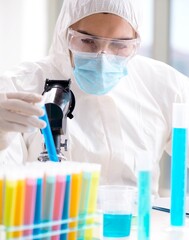 Young chemist student working in lab on chemicals