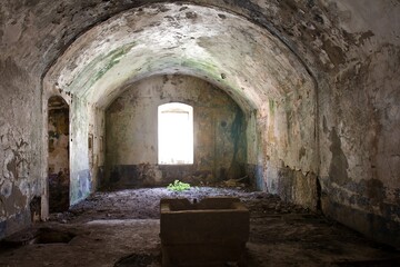Abandoned fortress Kabala in Montenegro. Old stone empty room with a window and some concrete well.