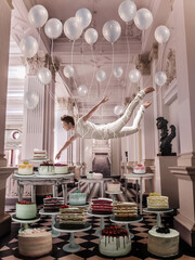 Man flying with balloons above cakes