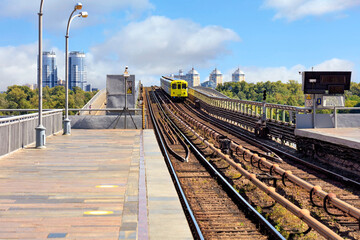 Fototapeta premium The metro train rushes through the metro bridge in Kyiv to the left side of the city.