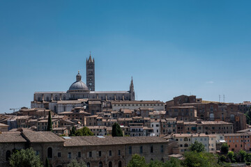 Fototapeta premium Sceneria Sieny w Toskanii, z widokiem na kopułę i dzwonnicę katedry w Sienie Duomo di Siena