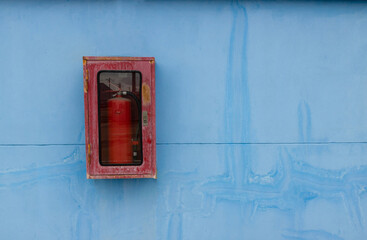Fototapeta na wymiar old red fire extinguisher in the old cabinet
