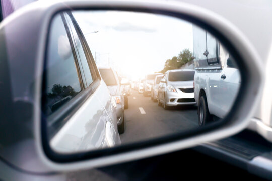 Abstract and blurred view from the side mirror of traffic congestion. Rear view of cars parked in long queues.  
