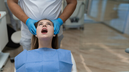 Close-up of a patient at the dentist being checked. She opened her mouth wide.