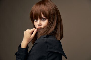 Sensual brunette European appearance black coat cropped view