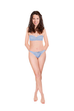 Full length portrait of an attractive cheerful woman wearing blue bra and panties, studio photo isolated in front of white background