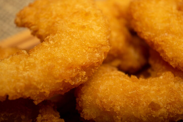 Atlantic prawns fried in batter on a wooden serving Board. Close up.