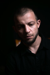 sad guy sitting on black background