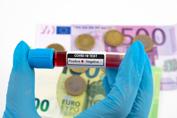 Test Coronavirus - positive result in the hand of a blue medical glove. Business and Economics. Background Euros.